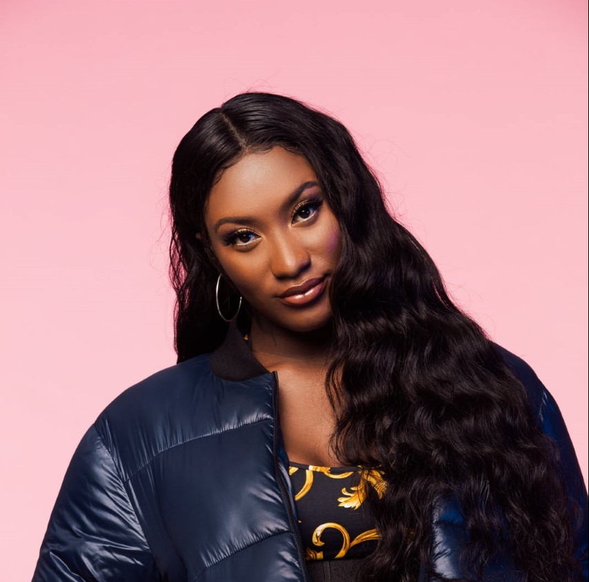 "Portrait d’un artiste hip hop en veste en jean et foulard rouge, micro à la main – performance immersive Vibes Concert"