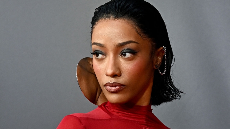 "Portrait d’un artiste hip hop avec t-shirt rouge et boucle d’oreille sculpturale – accessoire stylisé Vibes Concert"