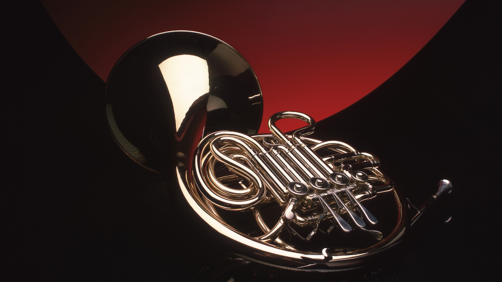 Un cor d'harmonie doré posé sur un fond sombre, représentant la catégorie musicale Variété Française.